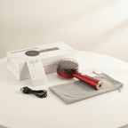 Red handheld hair dryer with packaging, user manual, and carrying pouch on a white background